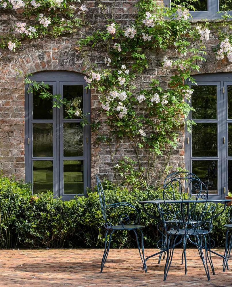 A black metal outdoor furniture set in front of a brick house