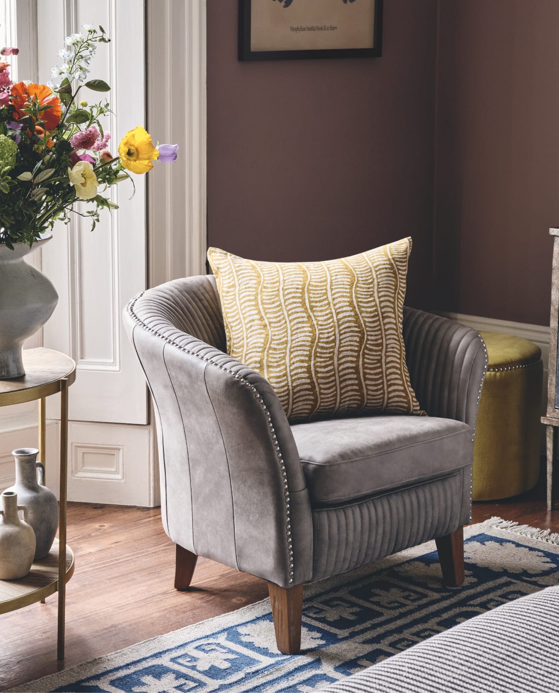 Crosby armchair in Ash Gray, with a yellow pillow on it