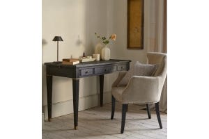 A black wooden desk with a herringbone linen armchair.