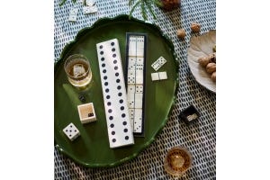 A dominoes gift set on a green tray.