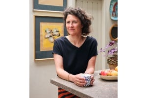 Lucy Hammond Giles wearing a navy T-shirt and holding a cup of tea