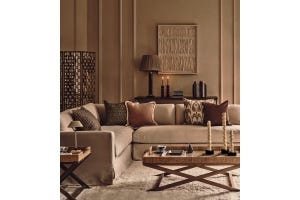A cozy sitting room with a sofa dressed in lots of pillows in front of feature wall art.