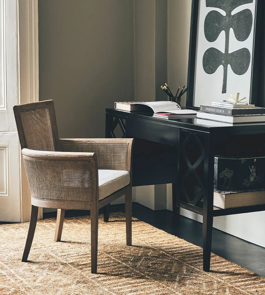 Rattan armed chair at a black desk