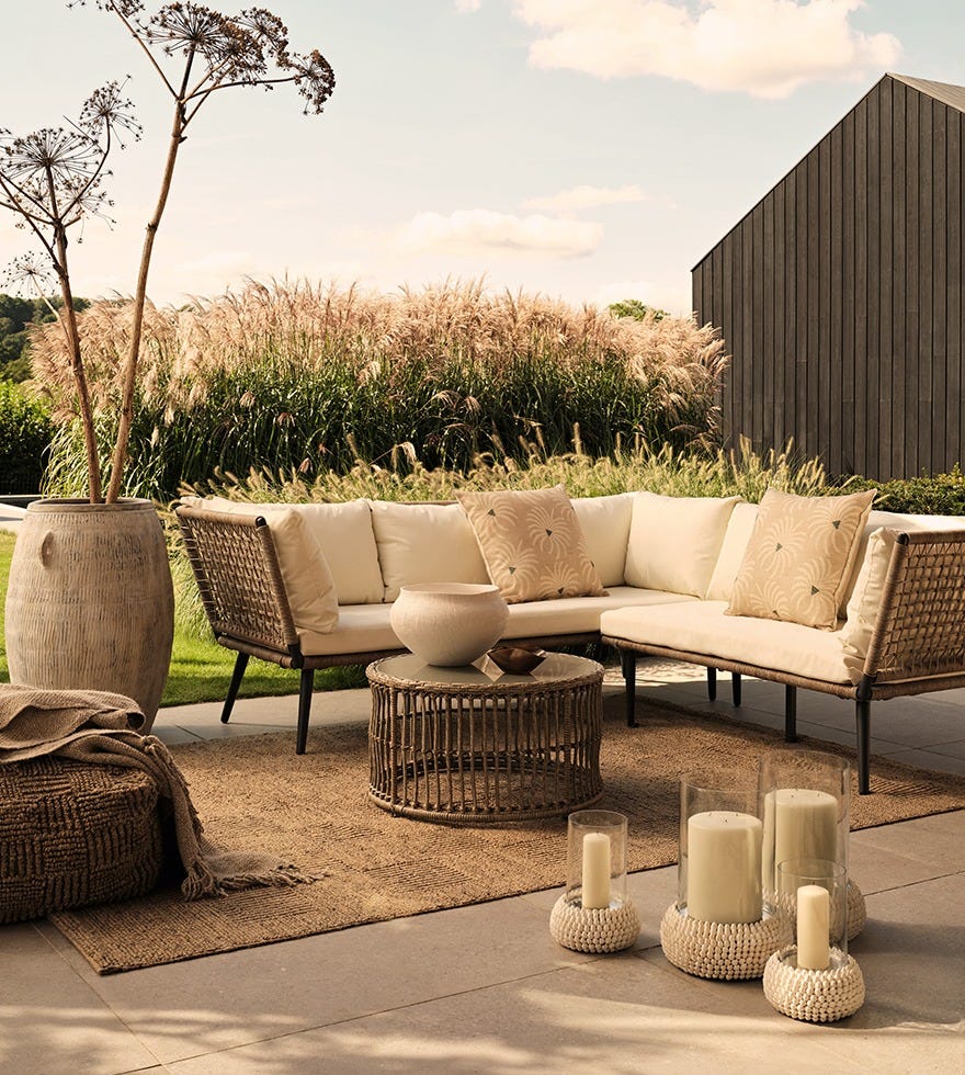 An outdoor lounge area including a modular sofa, coffee table, outdoor rug and accessories.