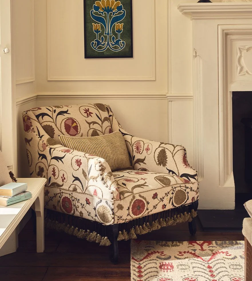 A feather-print armchair decorated with a floral cushion.