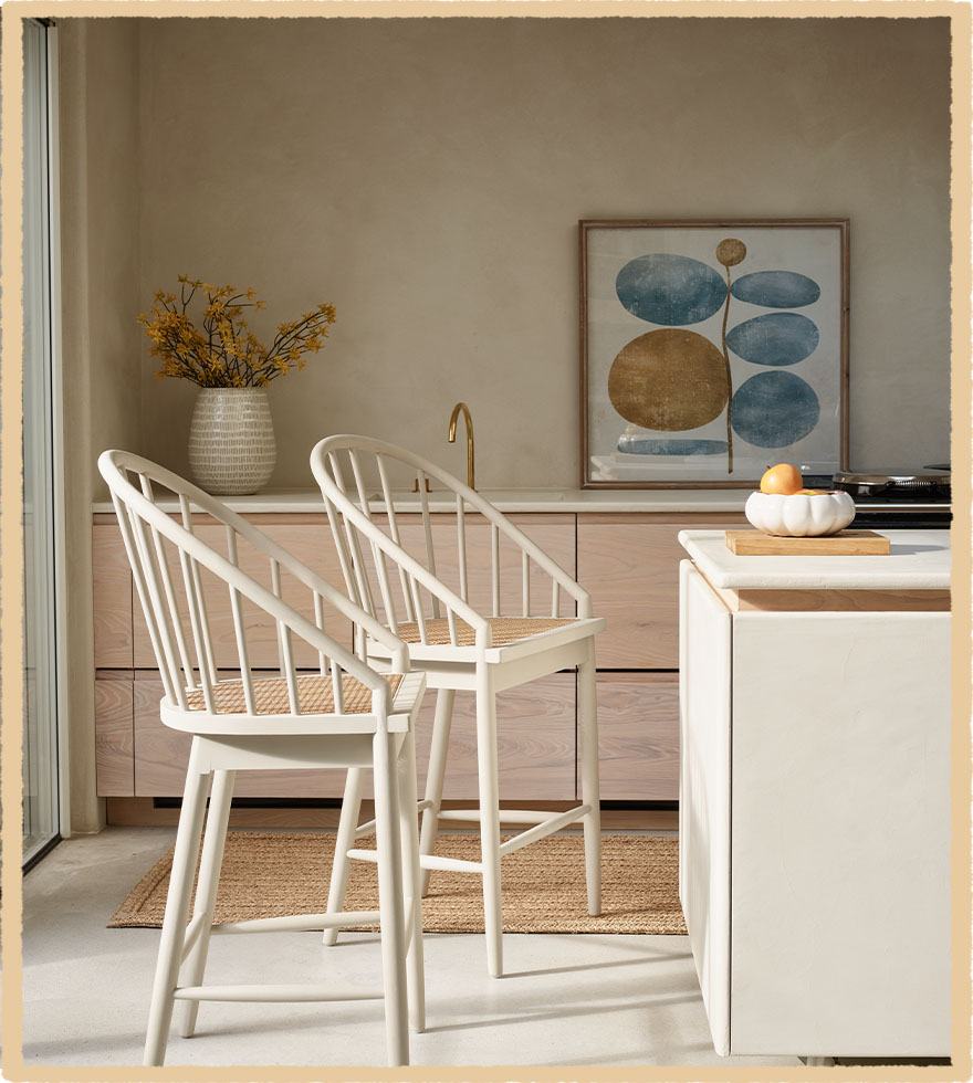 White, wooden bar-stools in a bright and airy kitchen