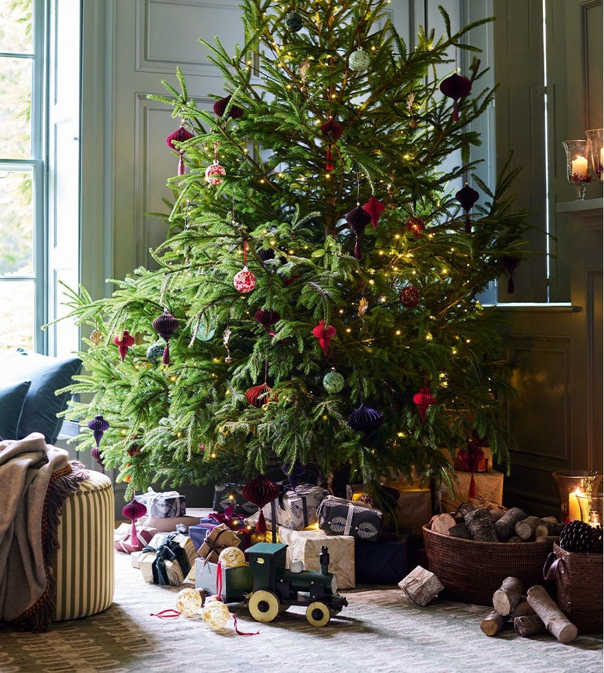 A real Christmas tree decorated with brightly coloured baubles and warm fairy lights