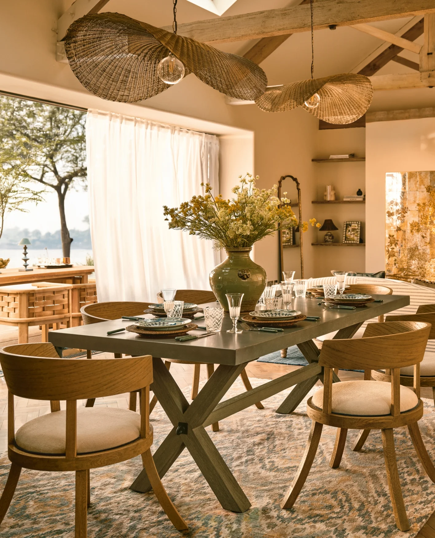 A yellow dining room with plants on the table.