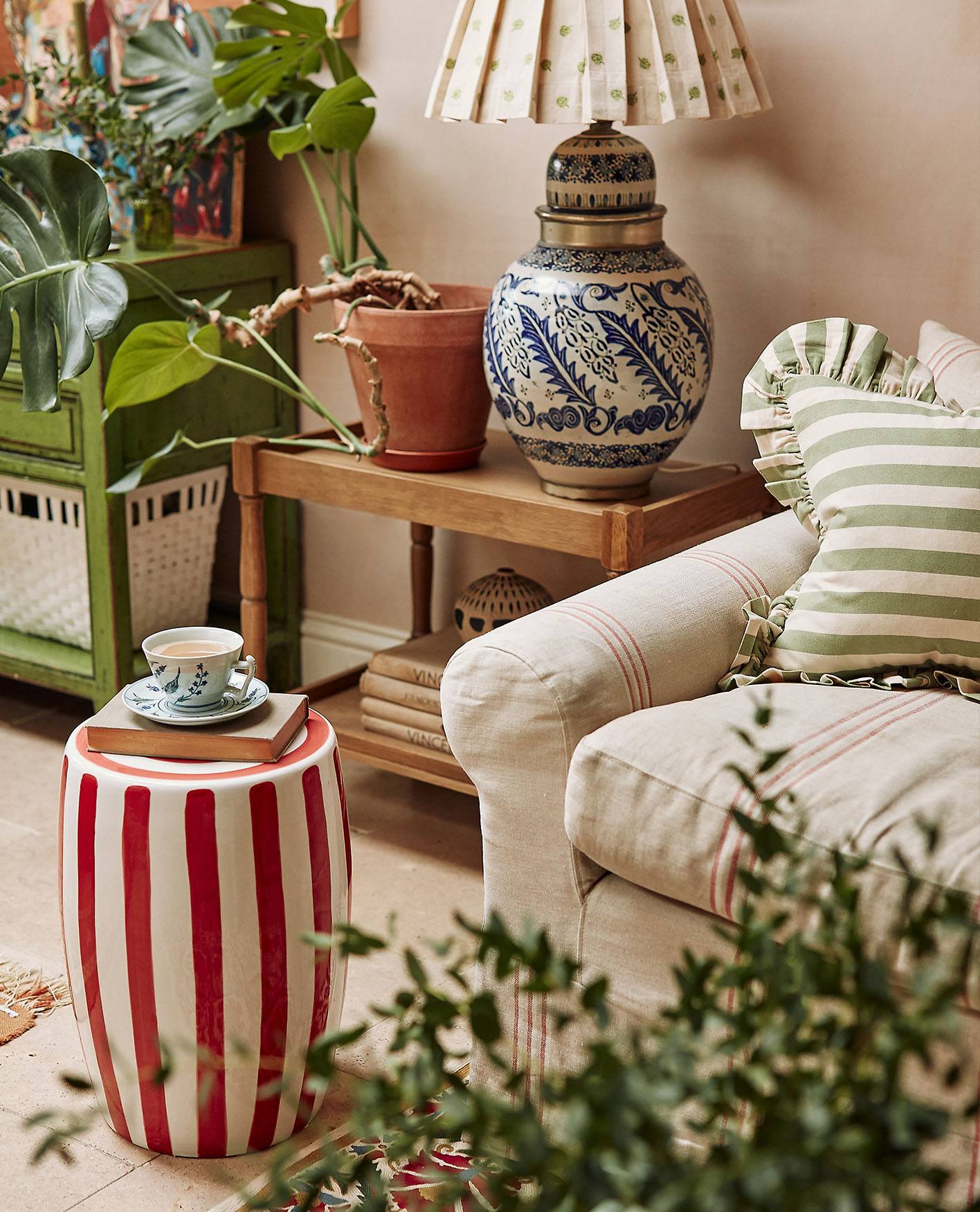 A teacup on a Rander stool surrounded by plants.