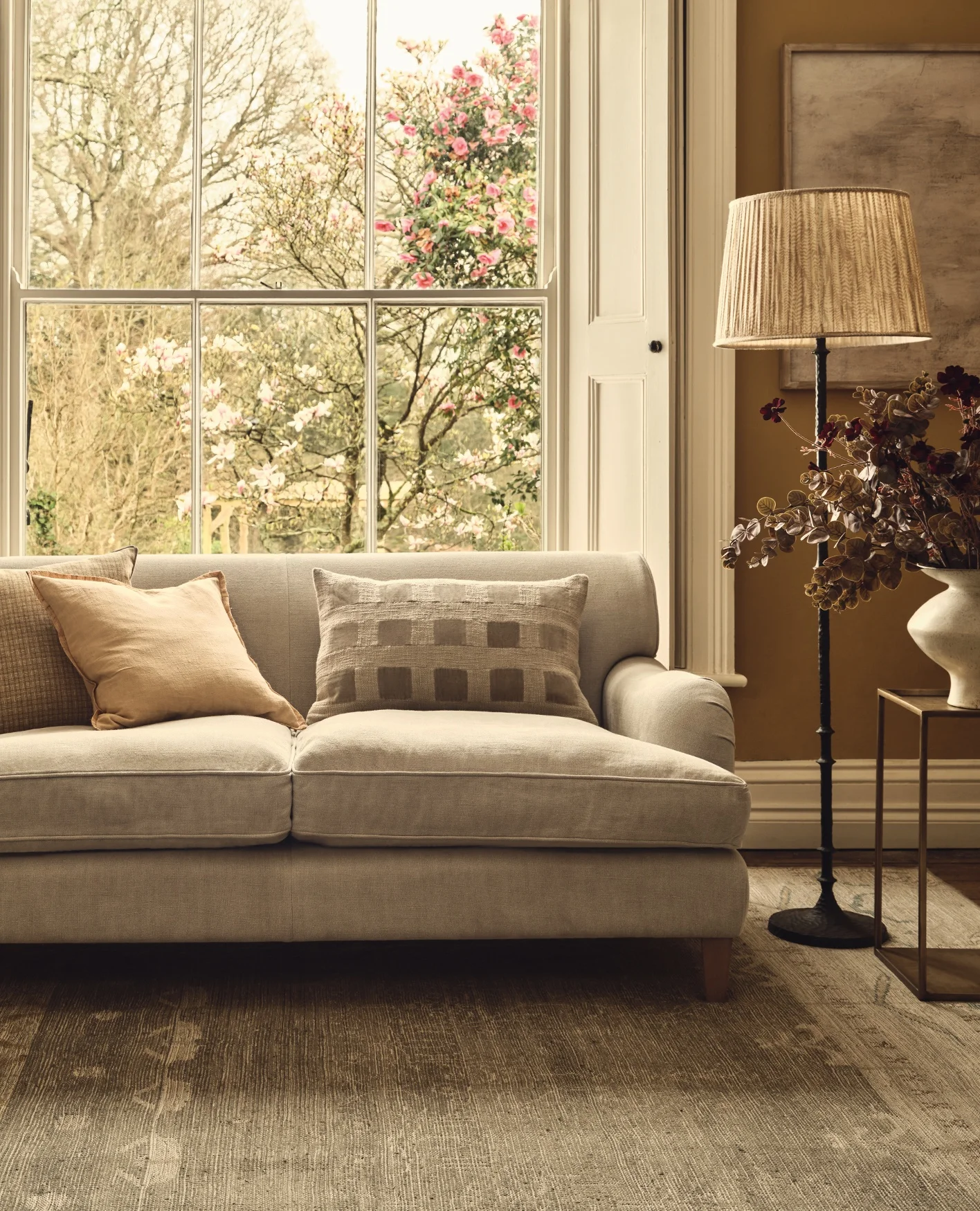 An abstract artwork of light colours hangs above a black sideboard decorated with monochrome accessories, including marble book ends.