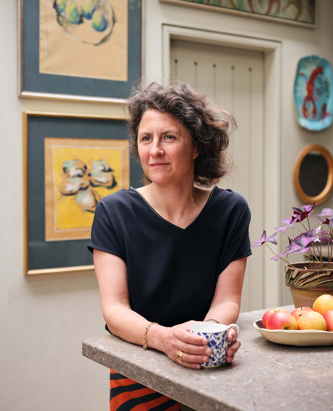 Lucy Hammond Giles wearing a navy T-shirt and holding a cup of tea