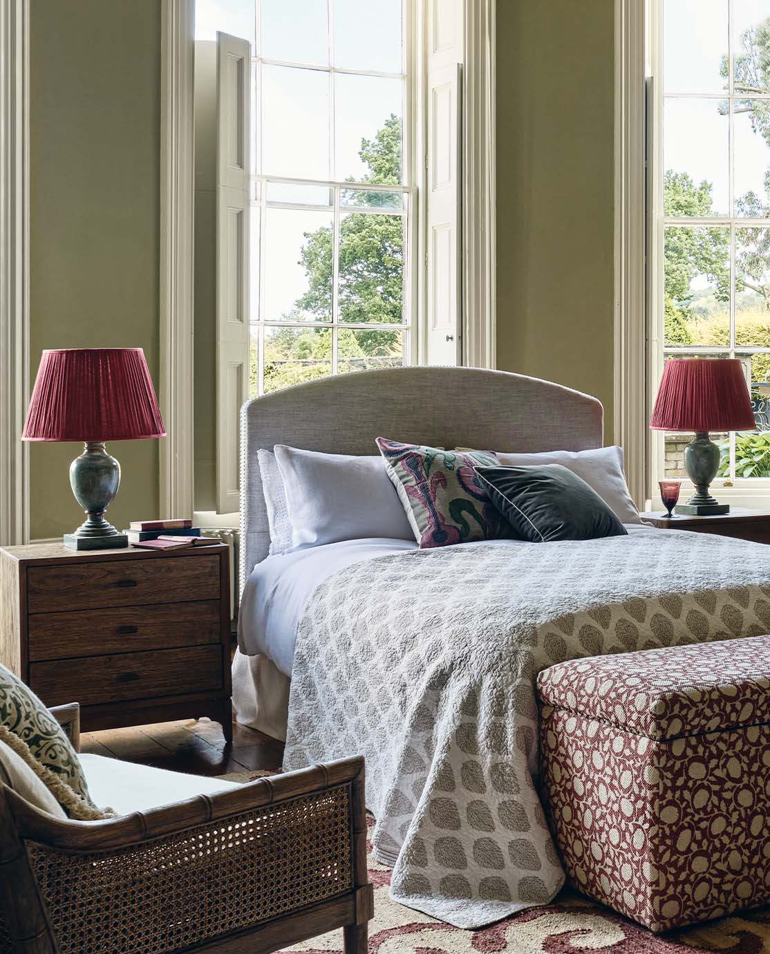 A cosy bedroom setting, with two wooden nightstands and a blue lamp on each one.