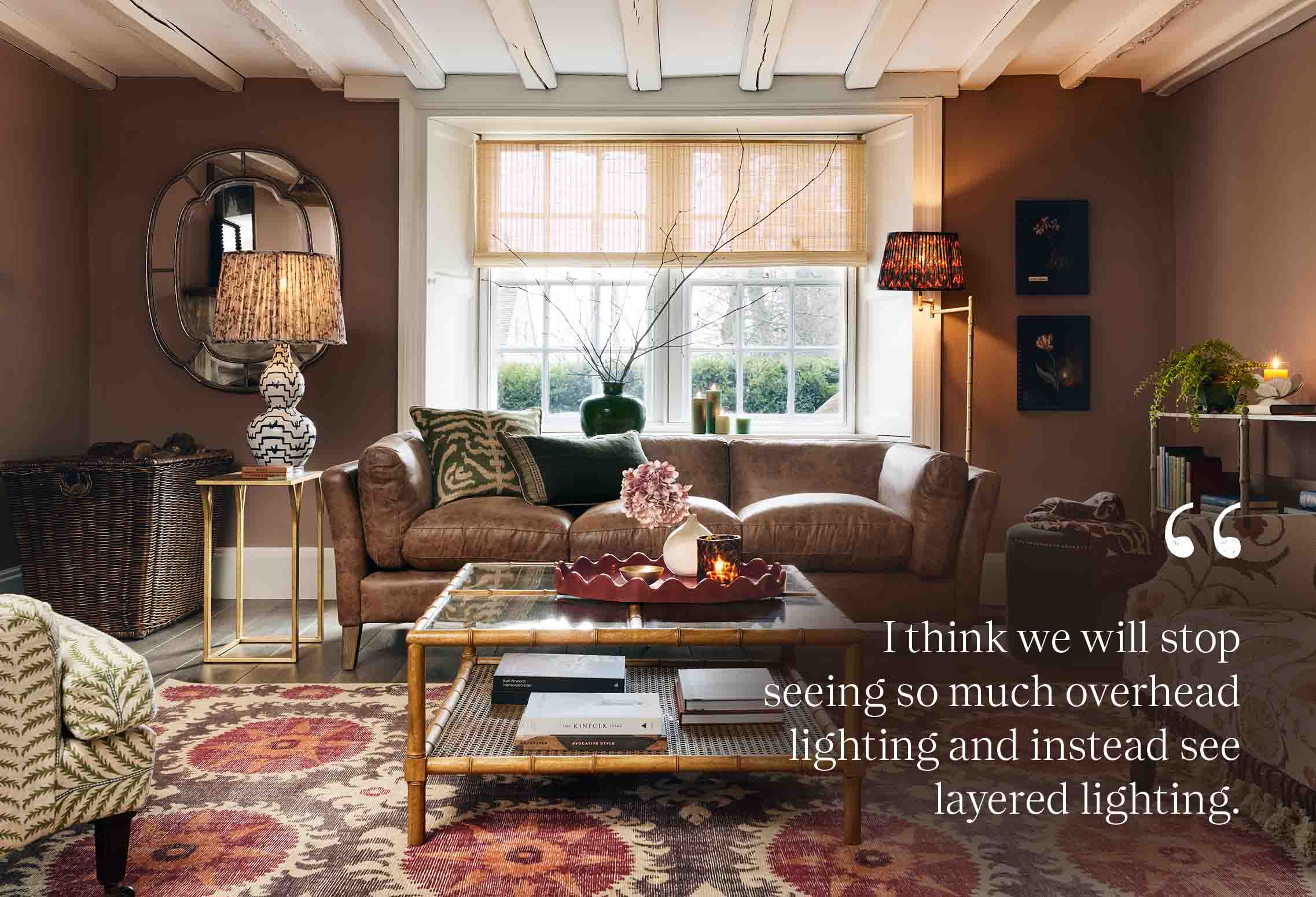 A cosy cottage sitting room decorated with pink tones, lots of pattern and lots of lamps.