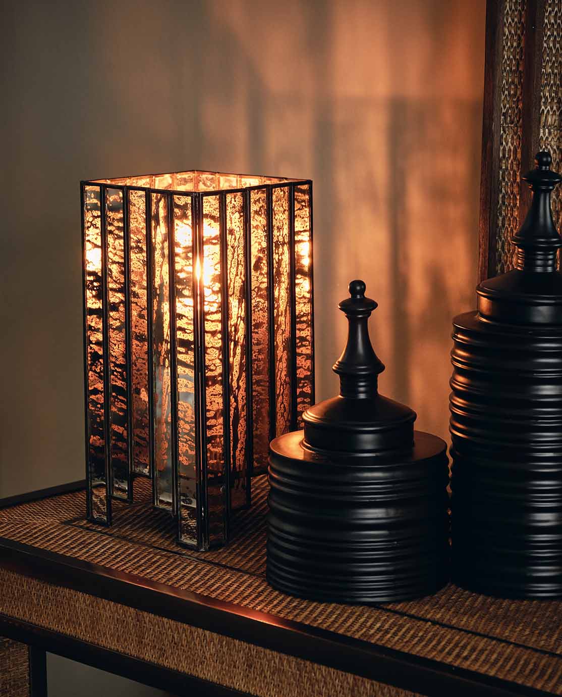 A candle lantern sat next to two sculptural black pots.