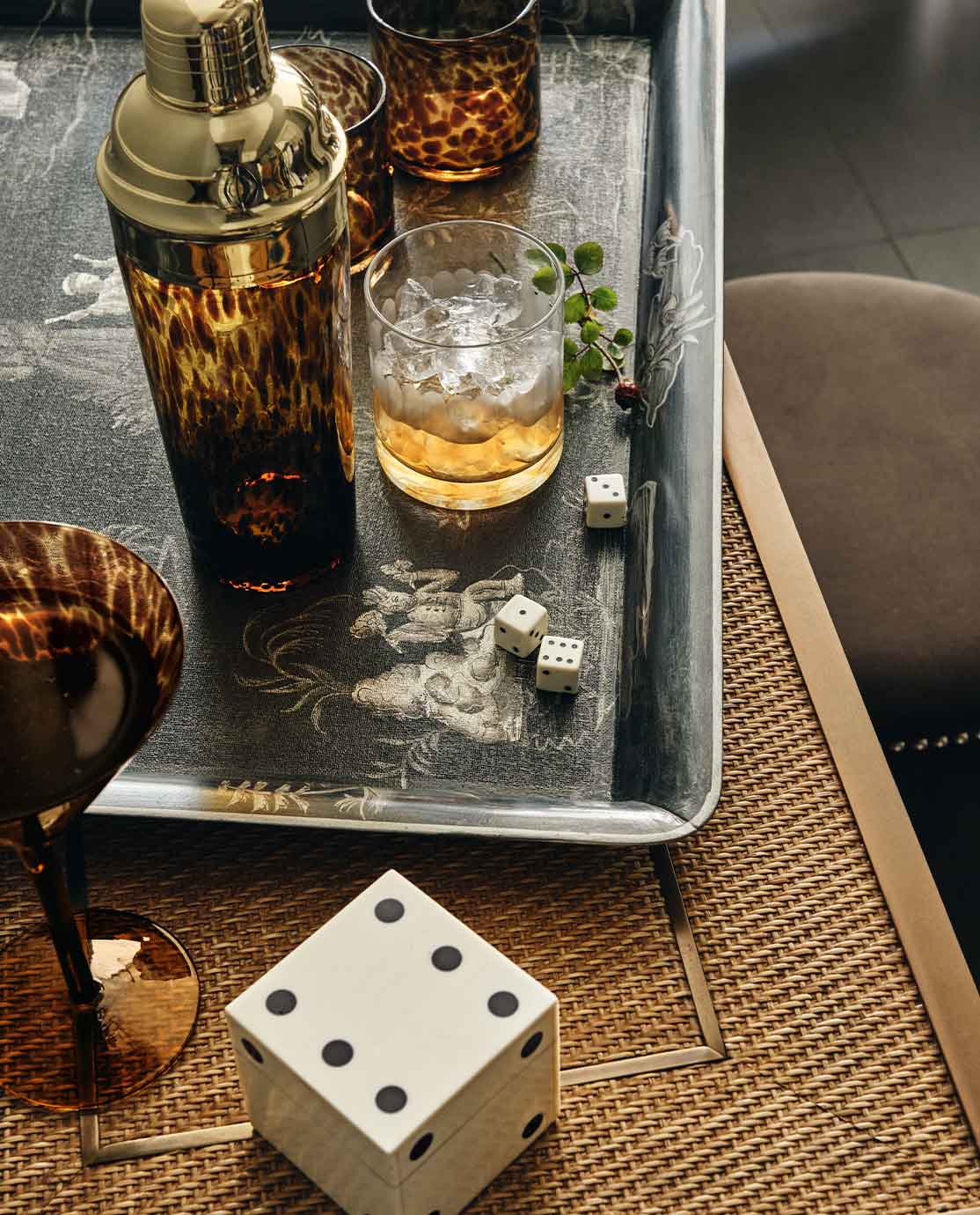 A console table featuring a stack of books and a plant, in front of a rustic mirror