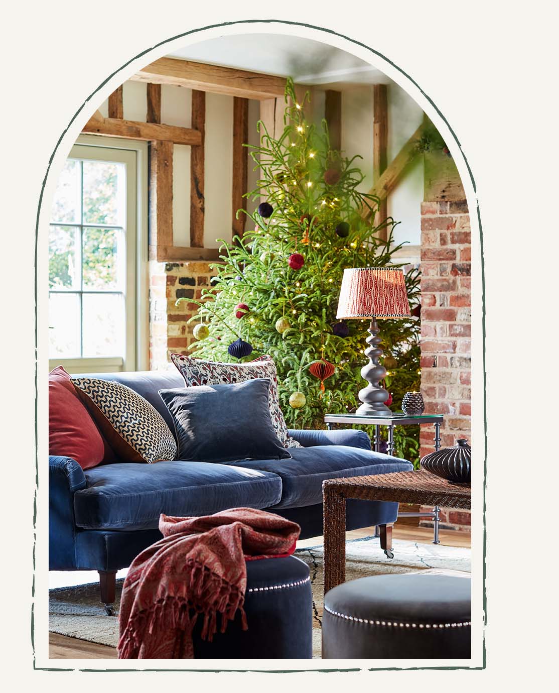 A festive set-up of a Christmas tree surrounded by presents in a farm-house style room