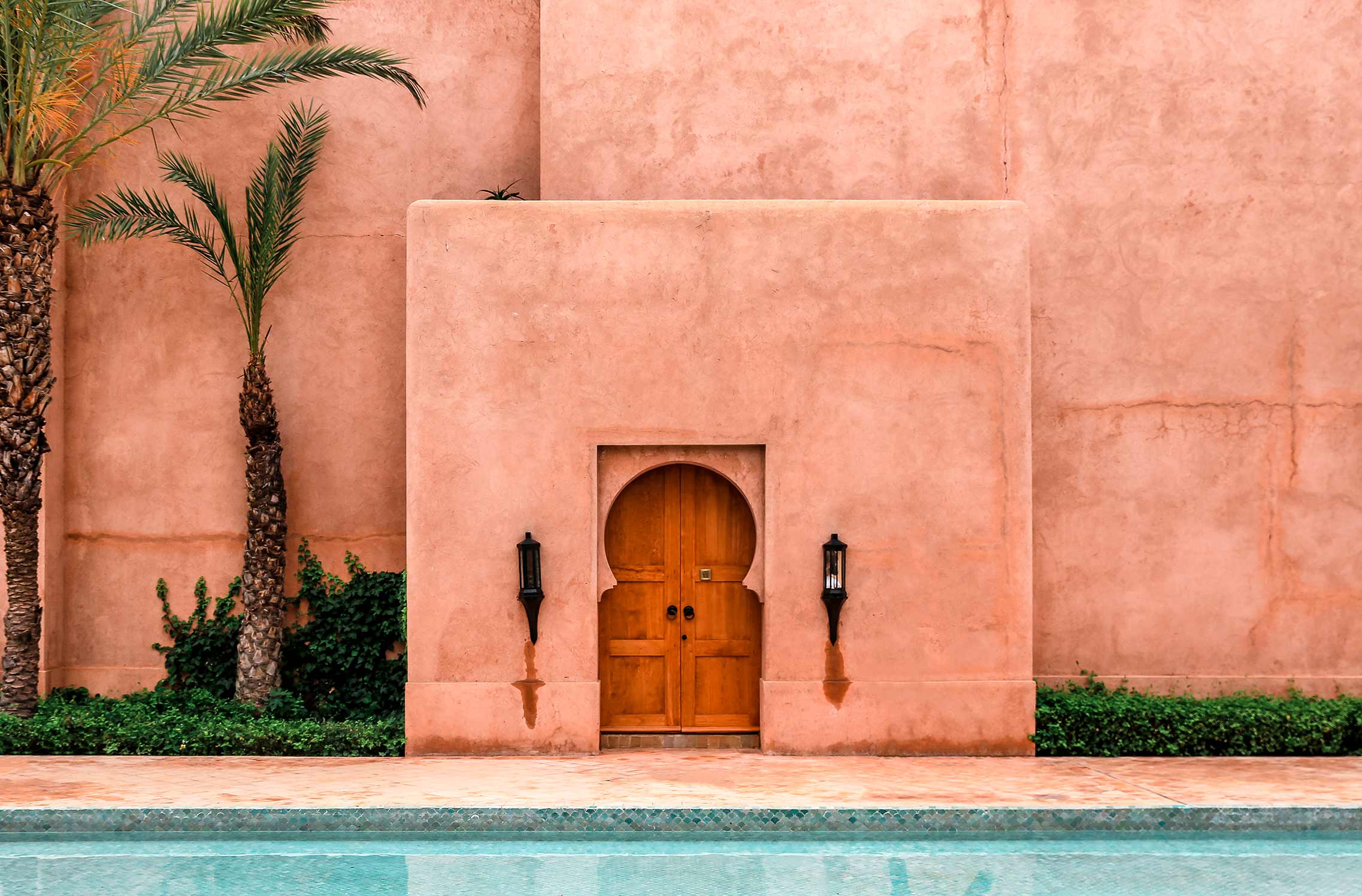 Red-walled building in Marrakech, in front of a swimming pool