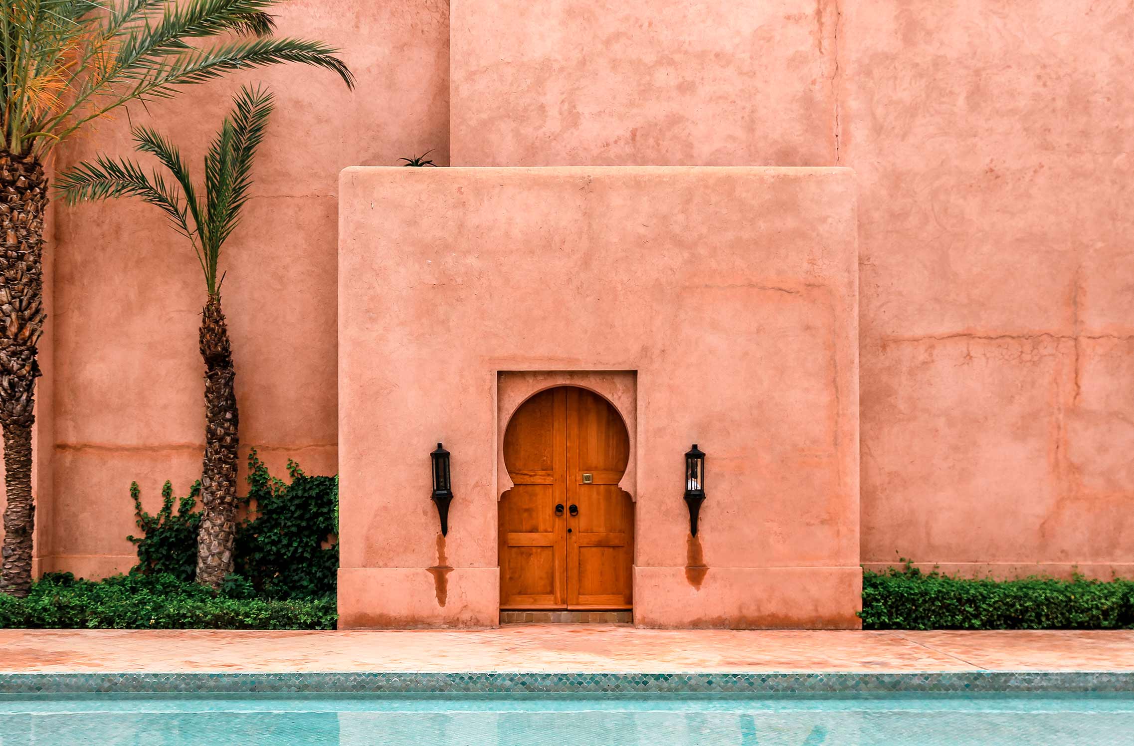 Red-walled building in Morocco overlooking a swimming pool