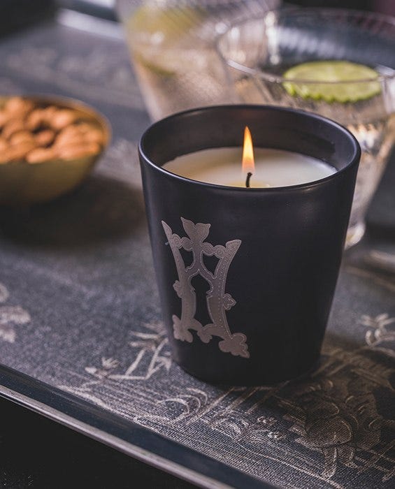 A lit Chronicle Collection candle on a coffee table