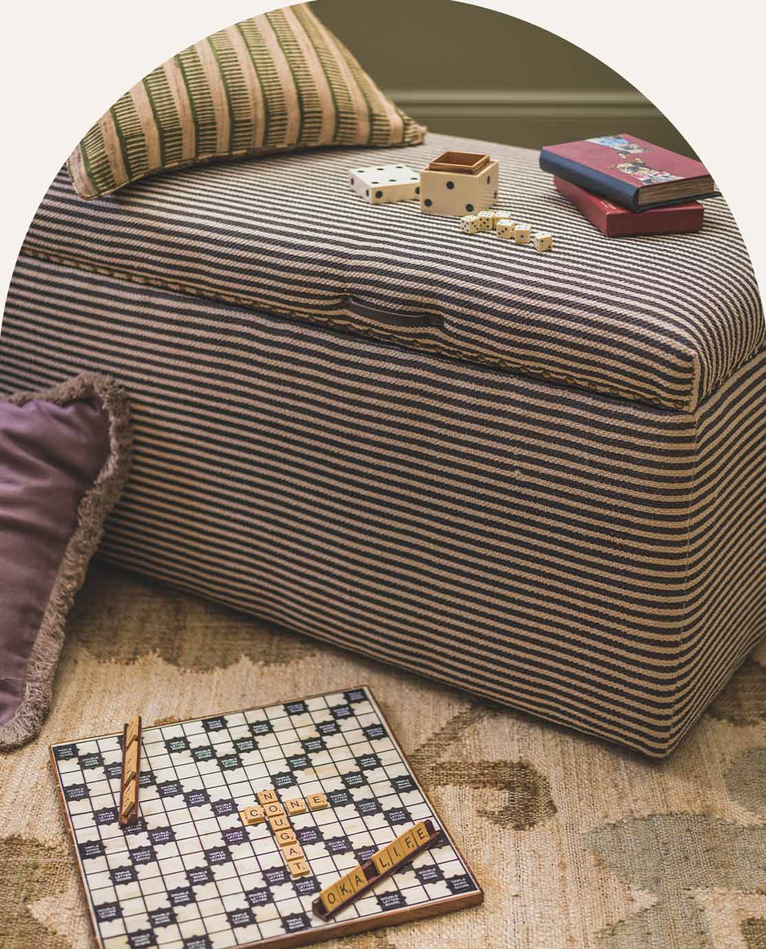 Striped ottoman, board games and cushions