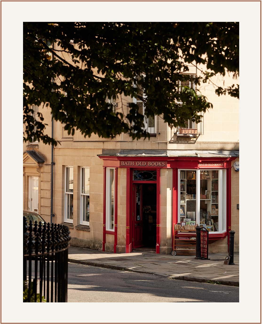 A store front, which is painted red and reads 'Bath Old Books' in gold writing. 