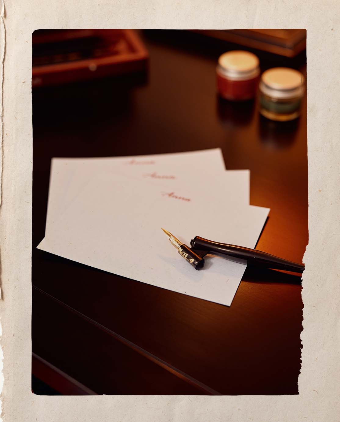 A calligraphy pen on top of a set of personalised notecards