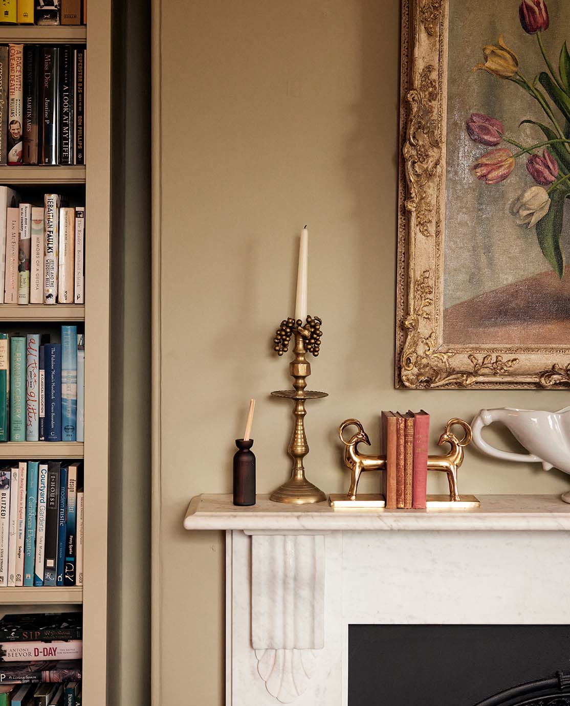 The corner of a mantelpiece decorated with a candlestick and ornaments.