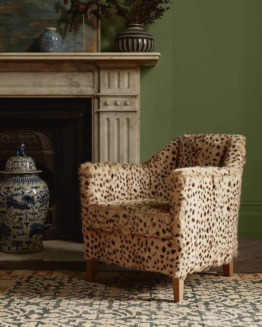 cheetah print armchair in front of a fireplace