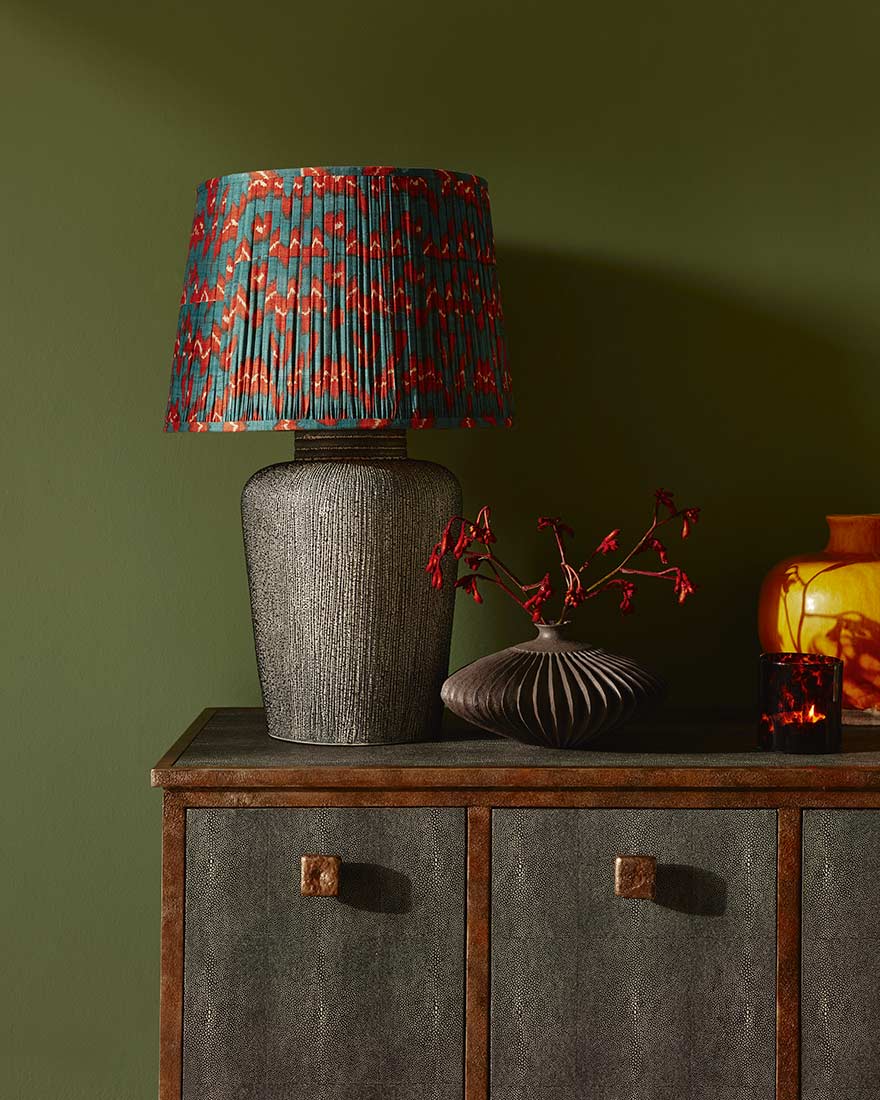 gray textured lamp with a bright red and blue shade