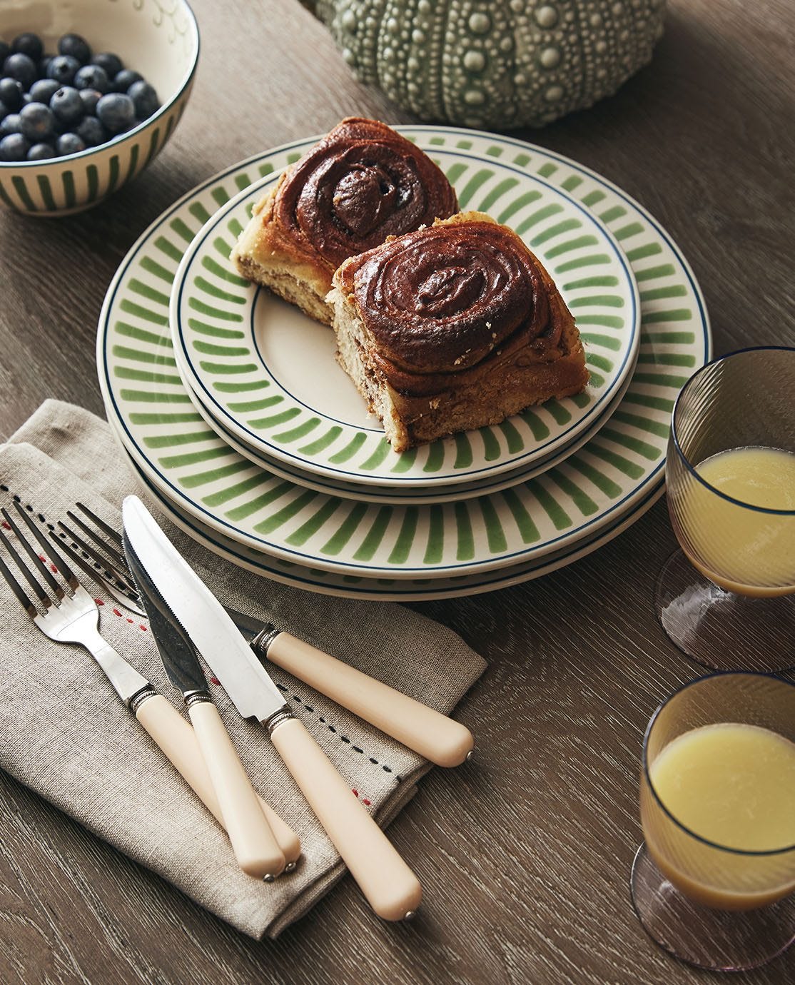 The Green Kinatro Crockery serving pastries, accompanied by a glass of orange juice and cream cutlery