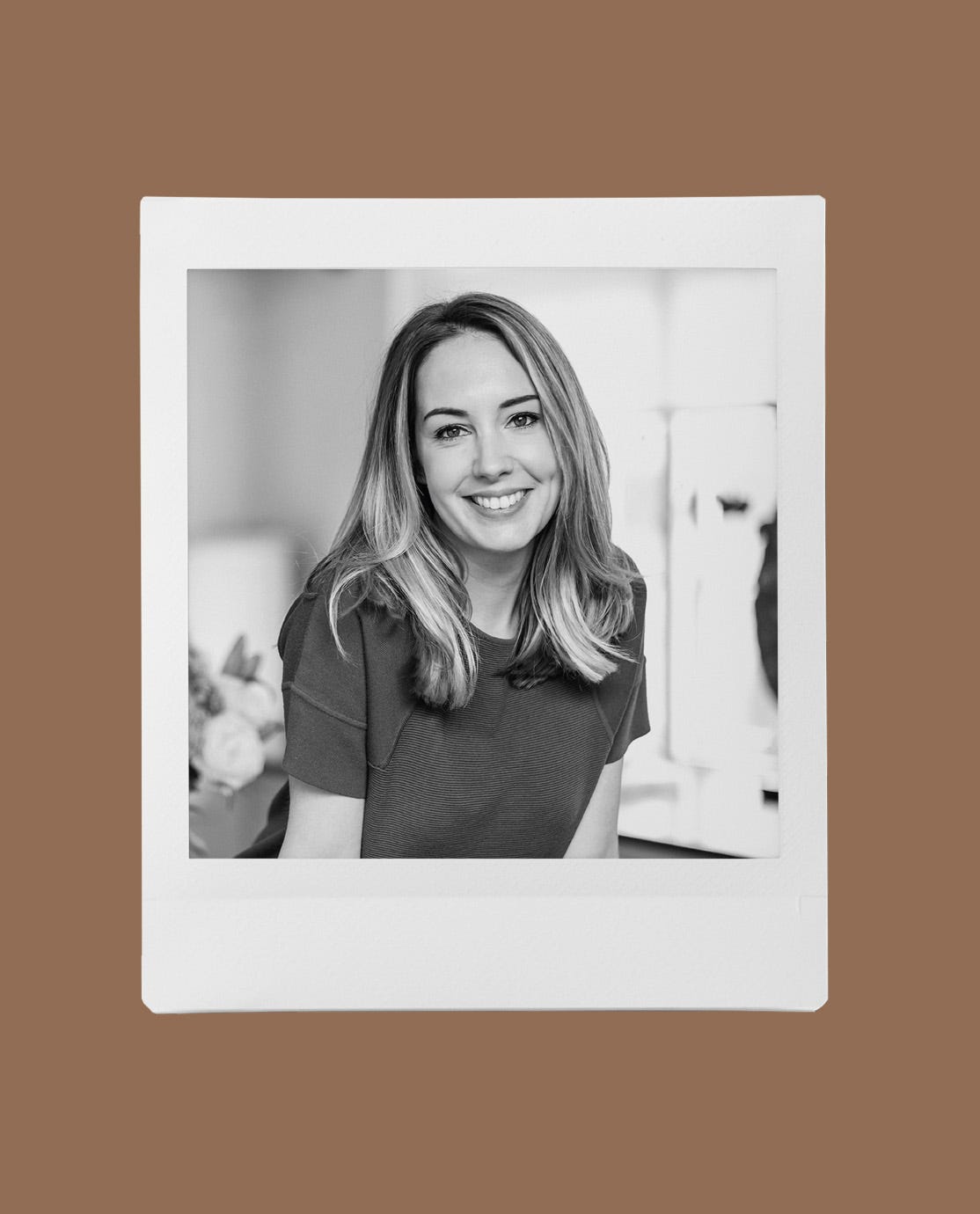 A black and white image of Lauren Caisley, wearing a T-shirt and smiling at the camera.