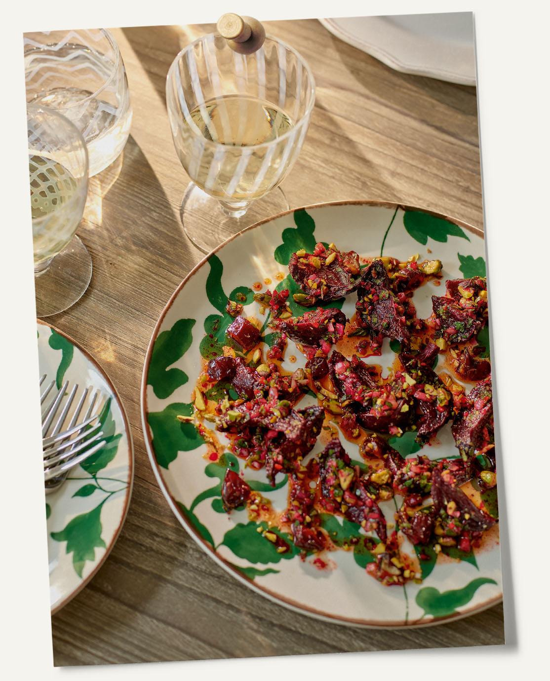 A beets dish served on a white-and-green leaf print plate