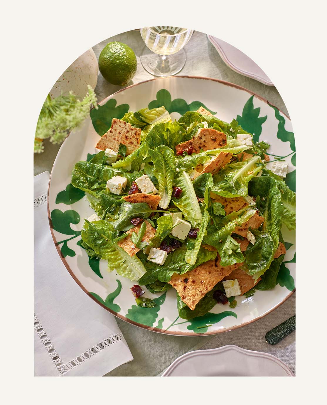 A colourful salad on a large serving plate decorated with a green ivy leaf print.