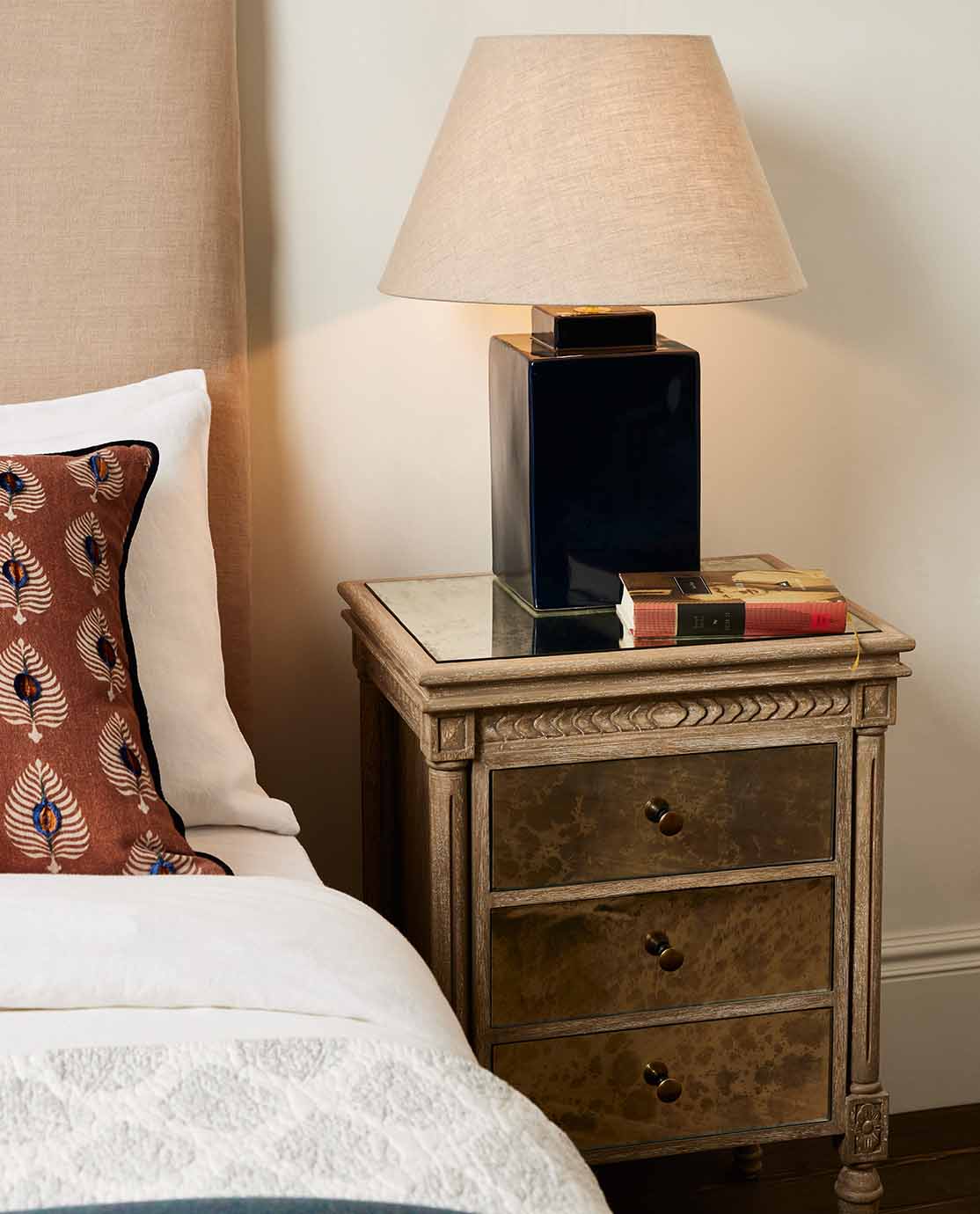 A aquamarine table lamp decorated with a pleated red lampshade