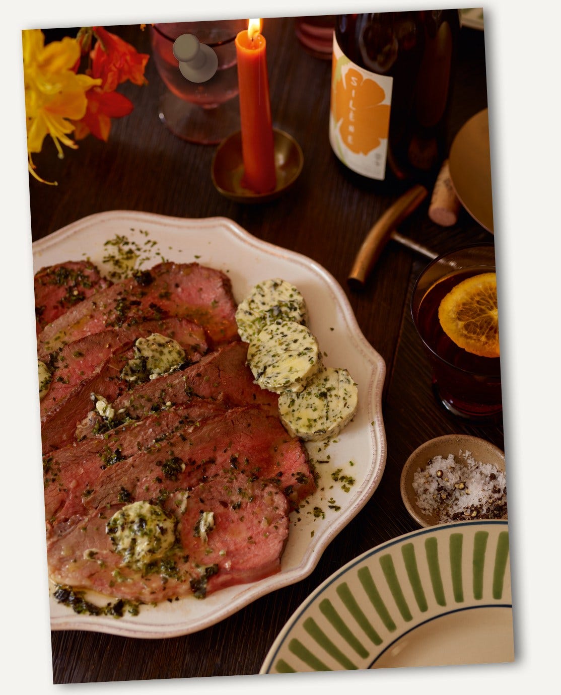 New York Strip Roast presented on a white ceramic platter.