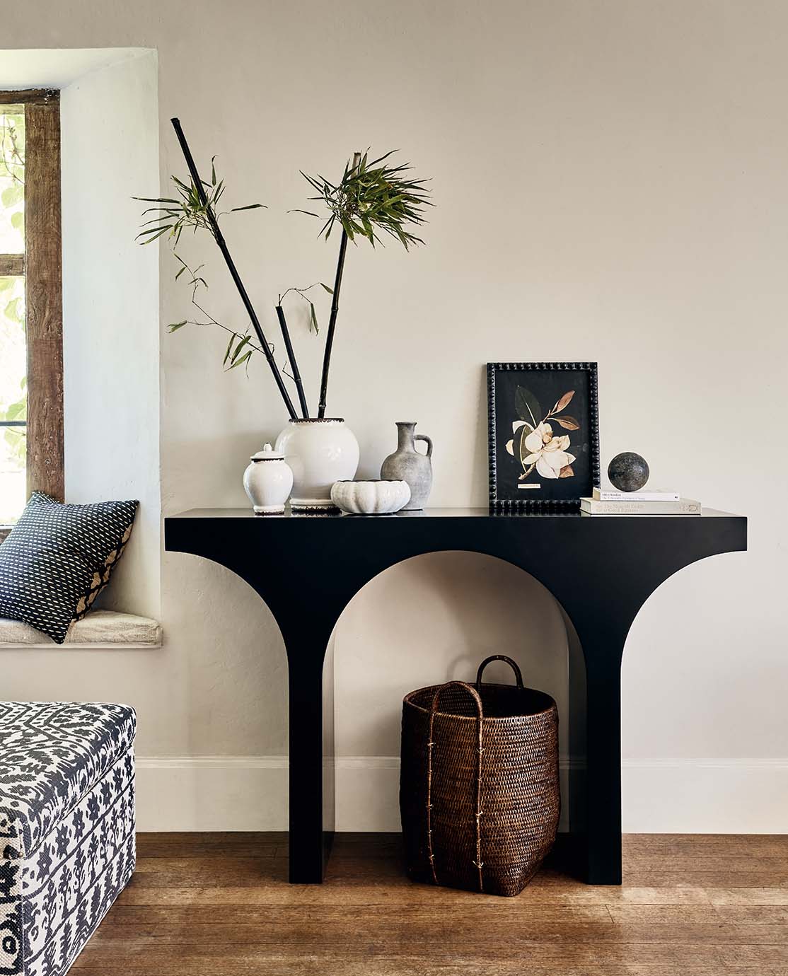 A sleek, curved console table decorated with floral accents