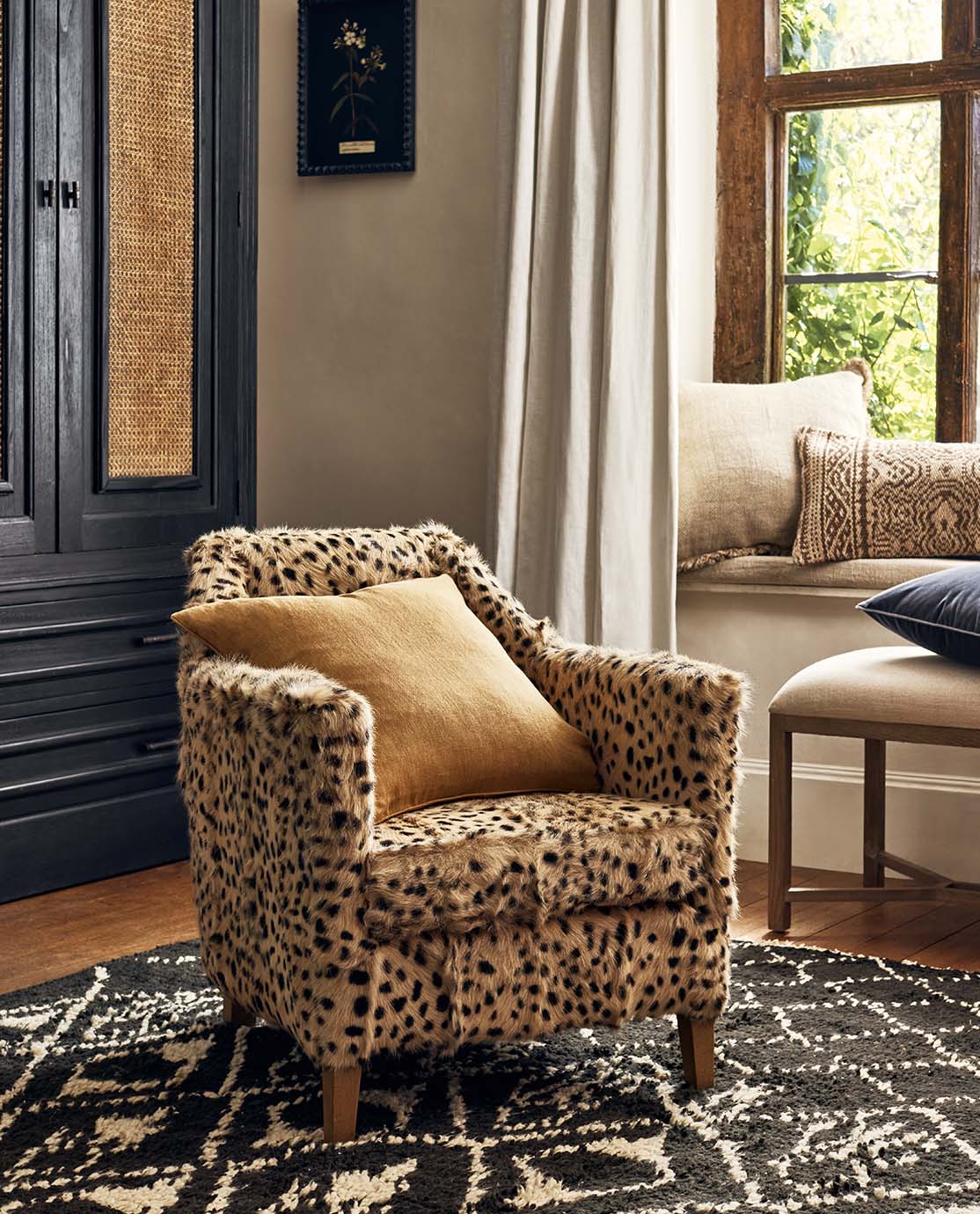 A goat-hair cheetah-print armchair decorated with a mustard yellow pillow