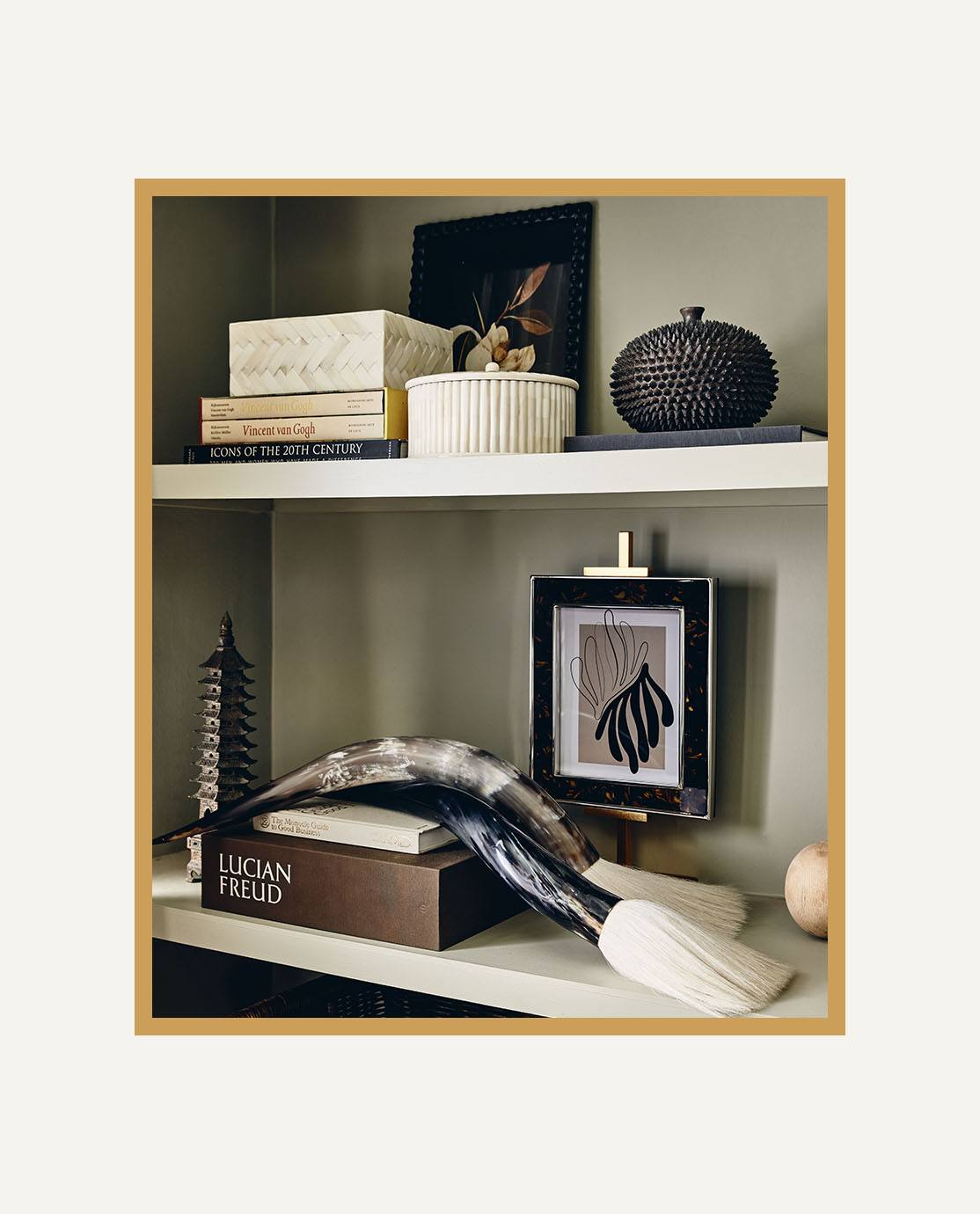 A close-up of white shelves decorated with monochrome ornaments and books