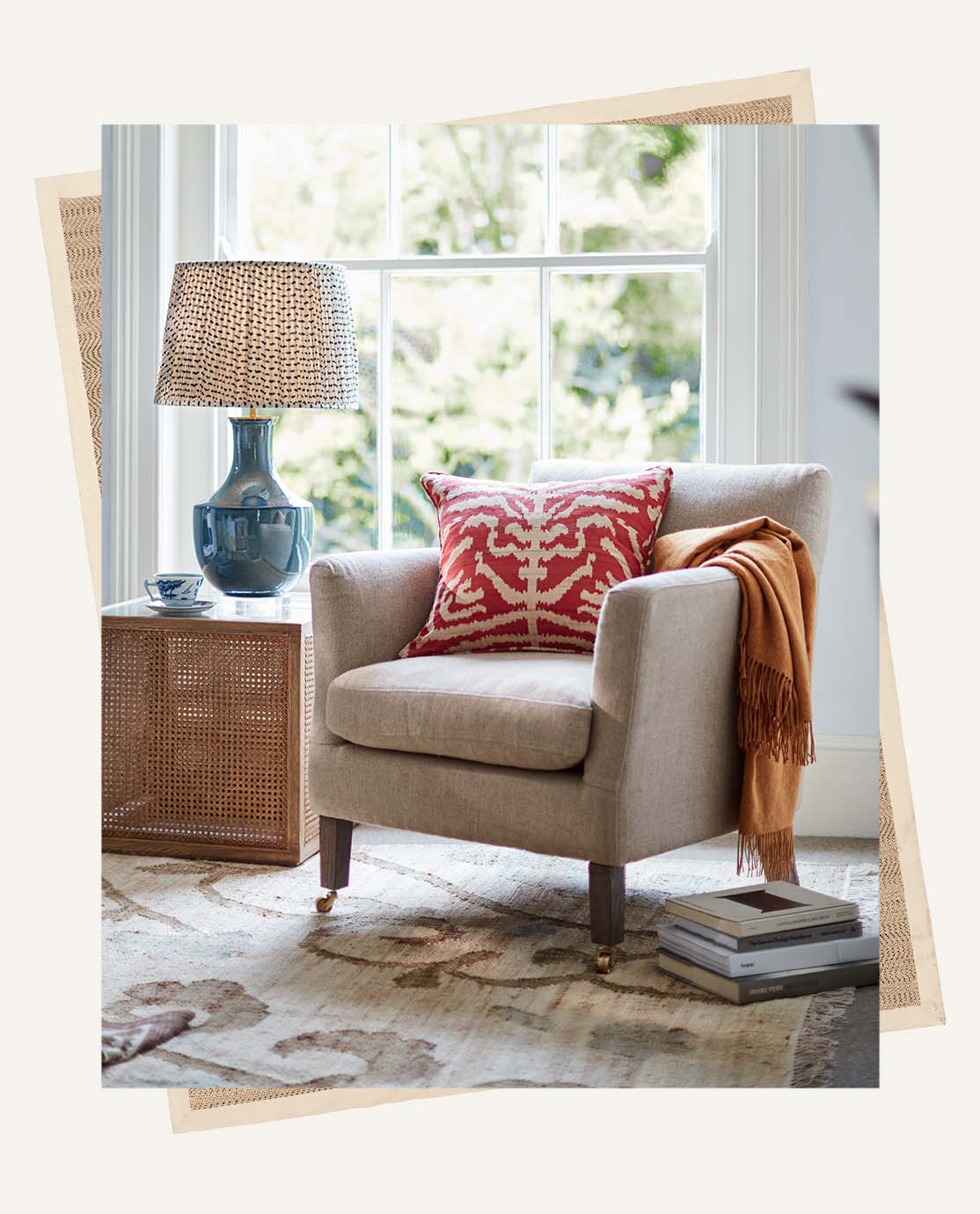 A beige armchair and wooden side table sit on a floral rug